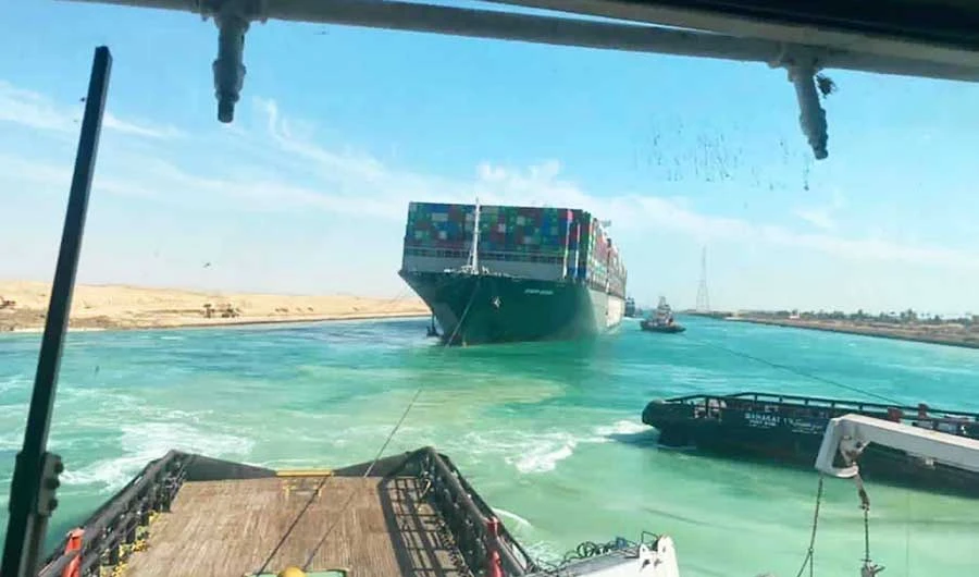 In this photo released by Suez Canal Authority, the Ever Given, a Panama-flagged cargo ship is accompanied by Suez Canal tugboats as it moves in the Suez Canal, Egypt, Monday, March 29, 2021. (AP)