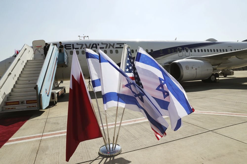 The national flags of Bahrain, Israel and America, flutter in near the Israeli flag carrier El Al plane that will fly an Israeli delegation. (AP)