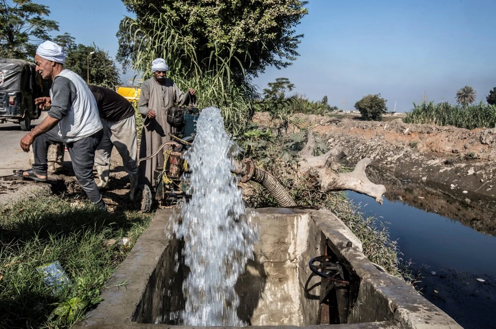 Egyptian farmers supply their farmland with water from a canal, fed by the Nile river, in the village of Baharmis on the outskirts of Giza province on Dec. 1, 2019. (File/AFP)