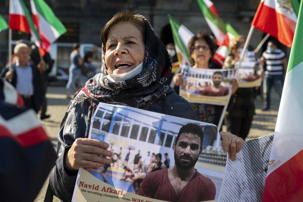 A woman holds a portrait of Iranian wrestler Navid Afkari during a demonstration in the Netherlands. (File/AFP)