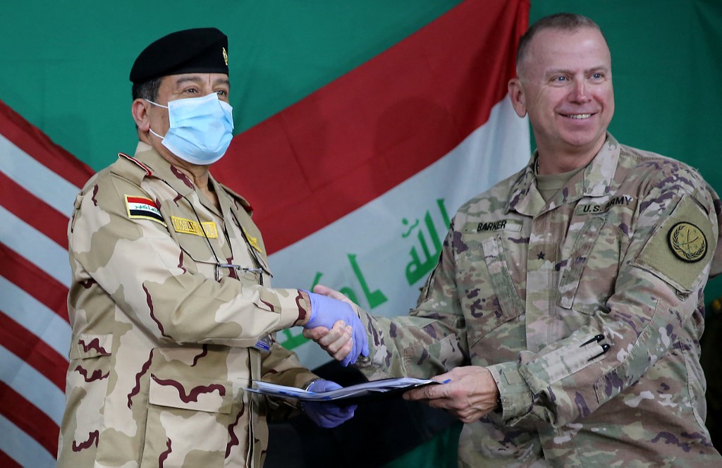Coalition’s Brigadier General Vincent Barker and Iraq’s Staff Major General Mohammad Fadhel Abbas shake hands during a pullout ceremony at the Qayyarah air base. (File/AFP)