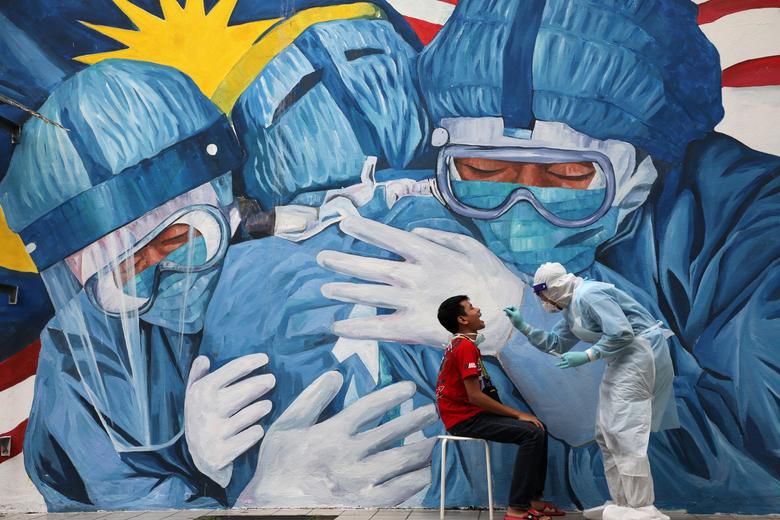 A doctor collects a swab sample from a man to be tested for the coronavirus outside Clinic Ajwa in Shah Alam, Malaysia, December 10, 2020. (Reuters)