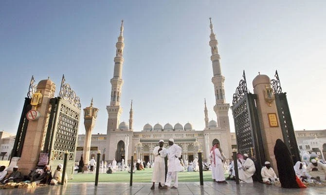 Muslim pilgrims wait in the courtyard of the Prophet Mohammed Mosque for the evening prayer, in the holy city of Medina in Saudi Arabia on 11 December 2007. (AFP/File)