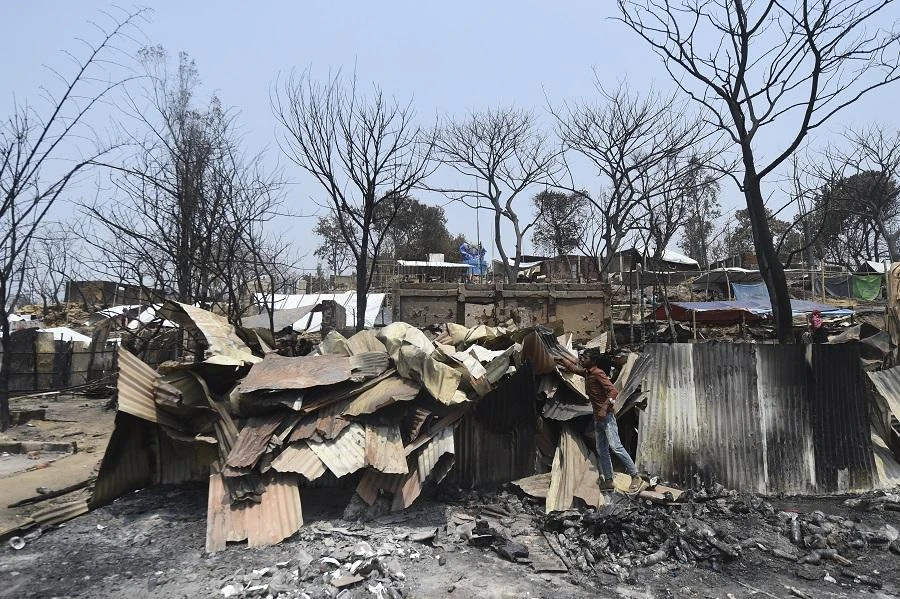 A Rohingya refugee man inspects burn tin sheets days after a fire broke out at a refugee camp in Ukhia, in the southeastern Cox's Bazar district on March 25, 2021. (File/AFP)