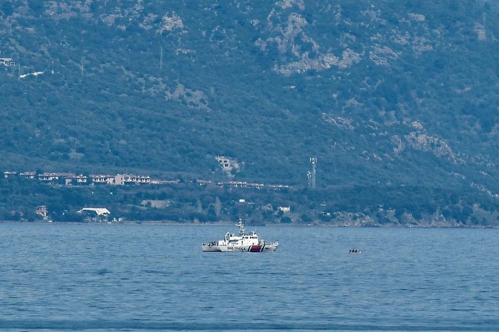 Turkish coastguard boat proceeds to check a inflatable boat at the sea between Lesbos island and the Turkish coast as part of operations to prevent boats of refugees of reaching the Greek coast on March 6, 2020. (File/AFP)
