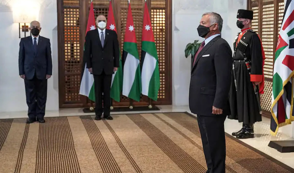 A handout picture released by the Jordanian Royal Palace on March 29, 2021 shows Jordanian King Abdullah II swearing-in the new health minister in the cabinet of Prime Minister Bisher al-Khasawneh in Amman. (AFP)