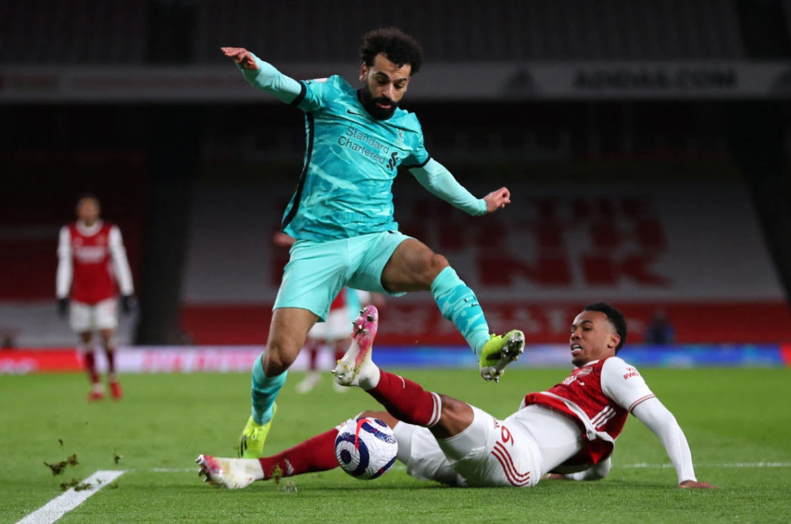Liverpool's Egyptian midfielder Mohamed Salah (C) jumps over a challenge from Arsenal's Brazilian defender Gabriel at the Emirates Stadium in London on April 3, 2021. (AFP)