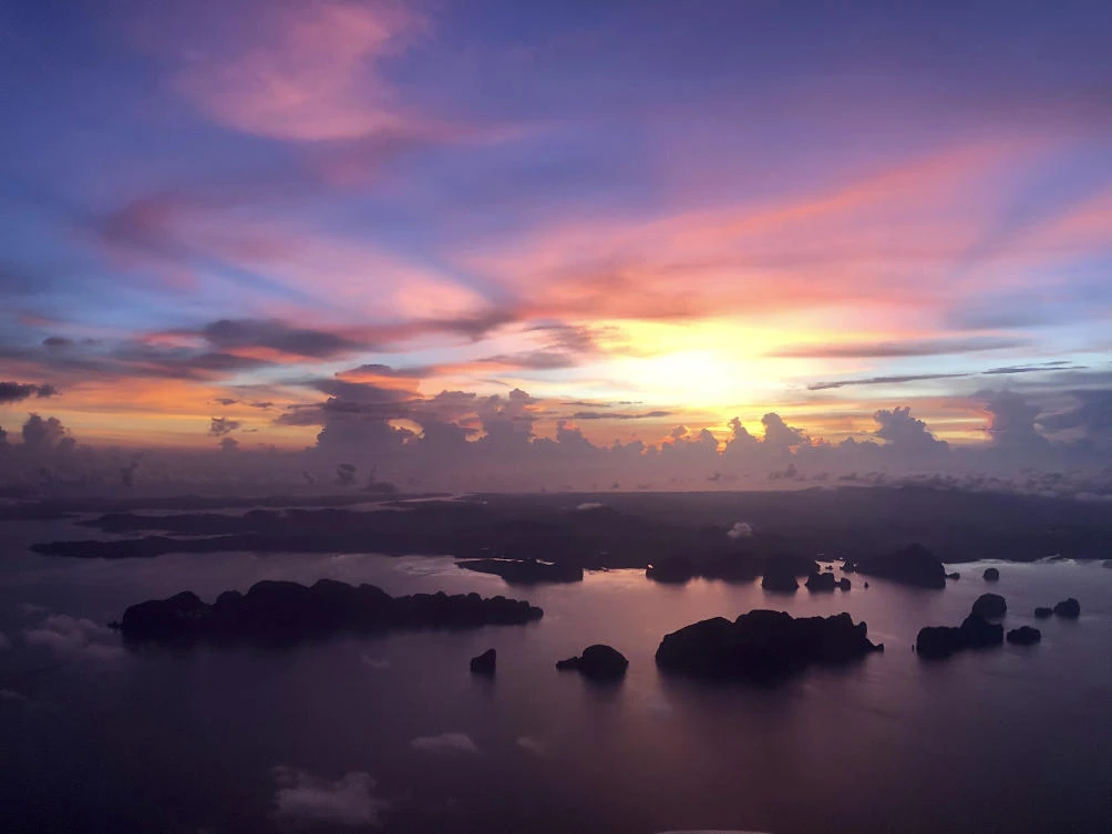 The sun sets over outlying islands as a plane prepares to land on the resort island of Phuket. (AP)