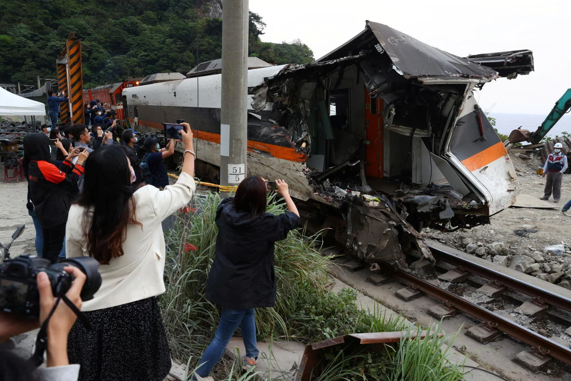 Members of the media document a damaged train carriage extracted from a tunnel after the deadly train derailment north of Hualien, Taiwan on April 6, 2021. (Reuters)