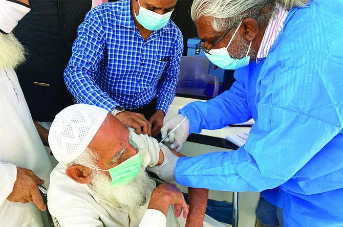 A 78-year-old inmate receives a dose of the coronavirus vaccine at Karachi Central Prison. (AN Photo)
