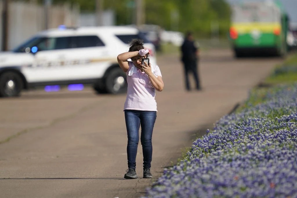 An employee from a local business talks on her phone after police released her from the scene of a mass shooting at an industrial park in Bryan, Texas on April 8, 2021. (AFP)