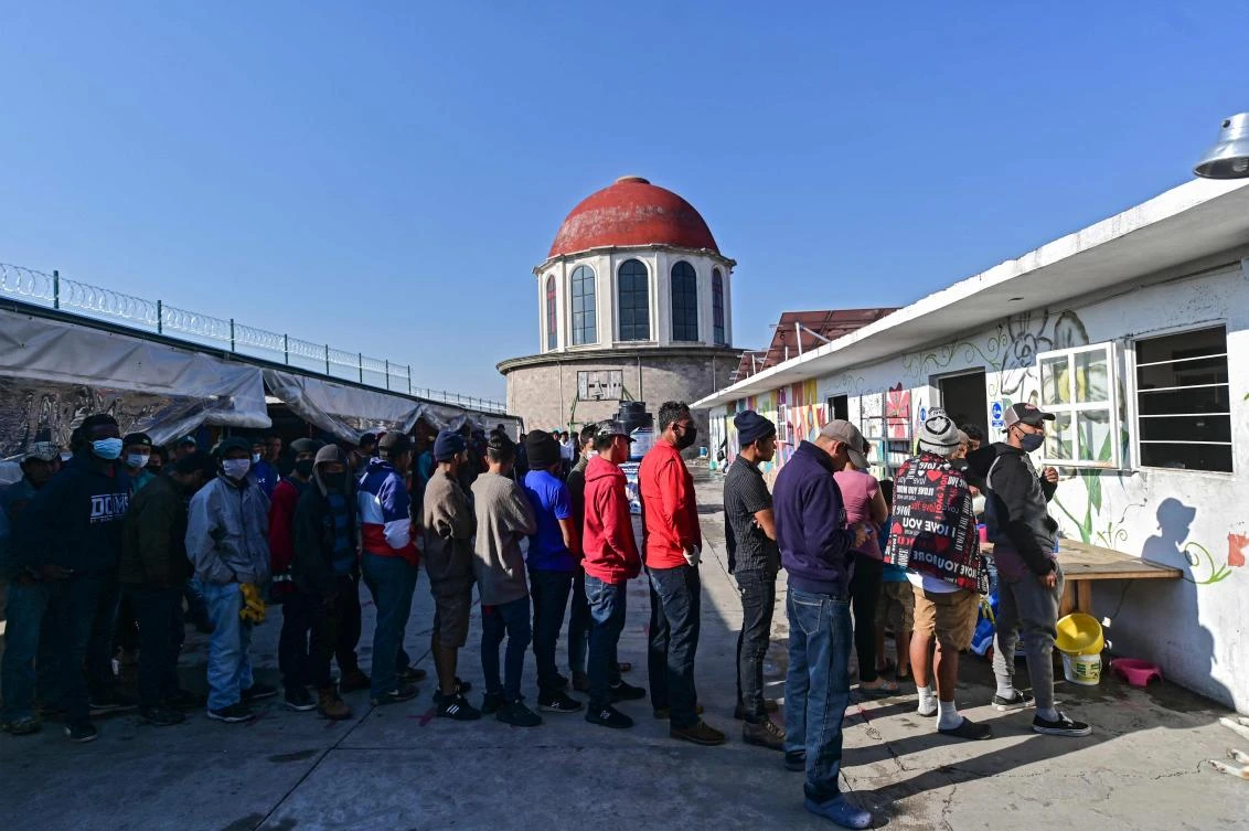 Central American migrants queue at the Sagrada Familia shelter as they wait for the so-called La Bestia (The Beast) cargo train in an attempt to reach the US border in Tlaxcala state, Mexico on April 9, 2021. (AFP)