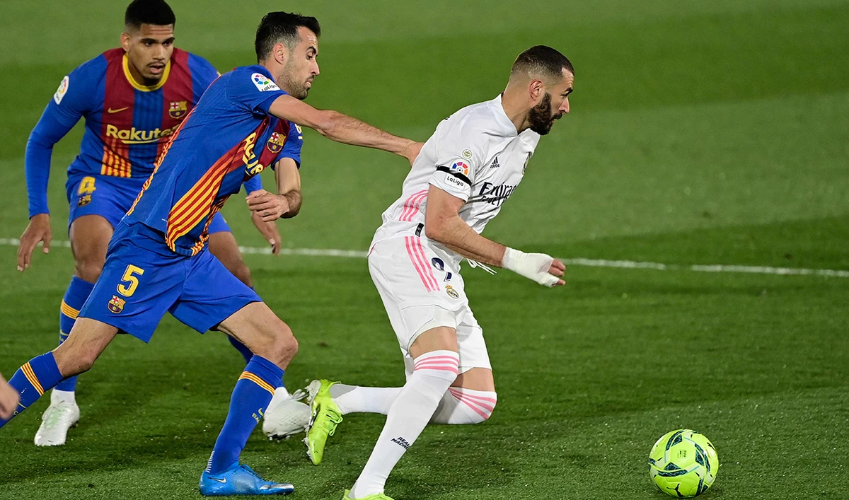 (FromL) Barcelona's Uruguayan defender Ronald Araujo and Barcelona's Spanish midfielder Sergio Busquets challenge Real Madrid's French forward Karim Benzema during the "El Clasico" between Real Madrid CF and FC Barcelona on April 10, 2021. (AFP)