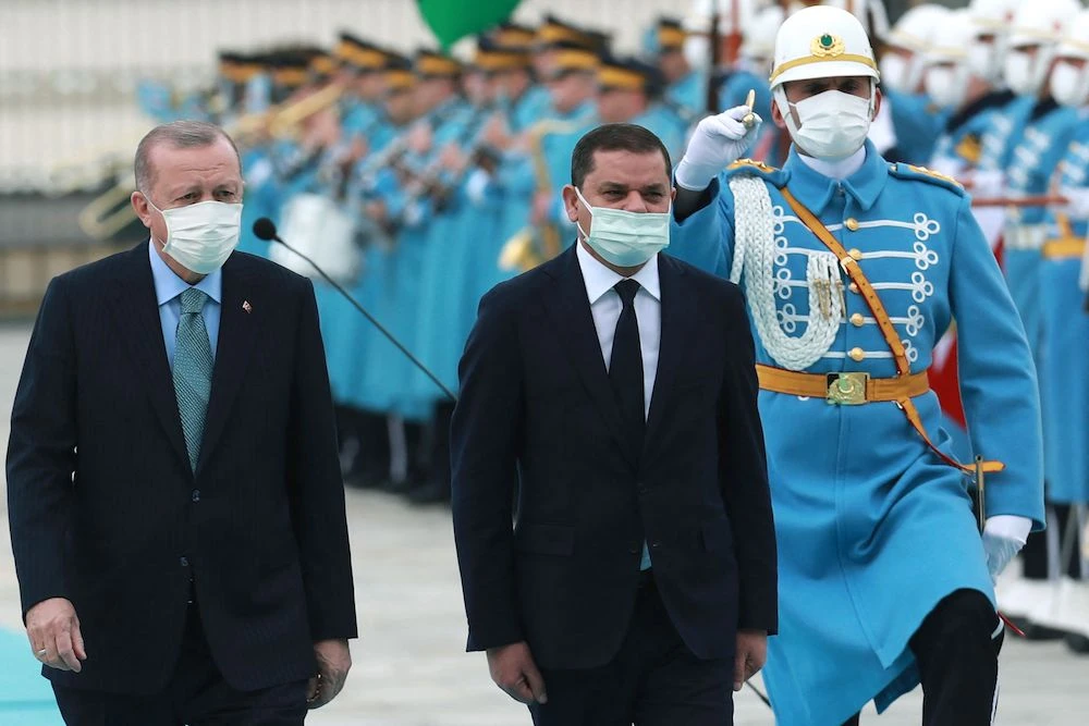 Turkish President Recep Tayyip Erdogan (L) and Libyan government of national unity prime minister Abdul Hamid Dbeibah (R) walk past honour guards during the official ceremony prior to their meeting in Ankara on April 12, 2021. (AFP/File Photo)