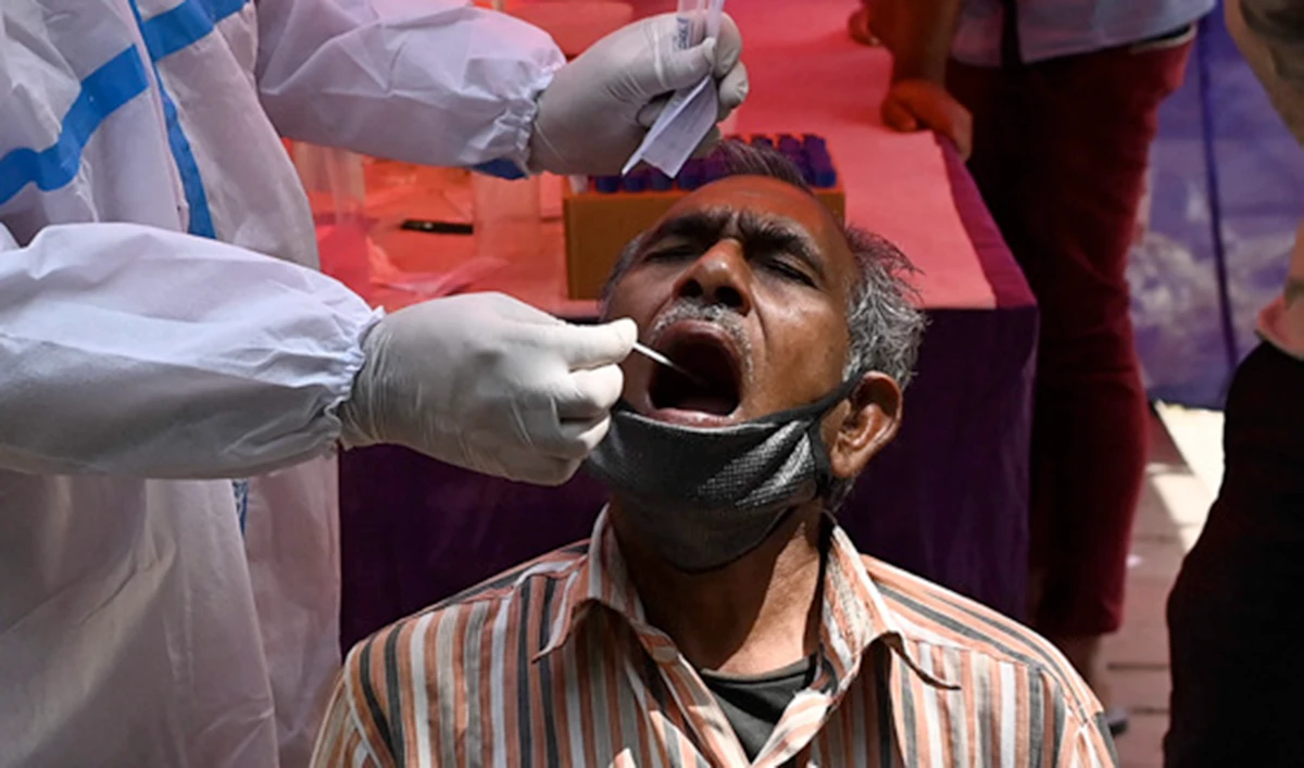 A health worker takes a swab sample from a man at a testing center in New Delhi on Monday. (AFP)
