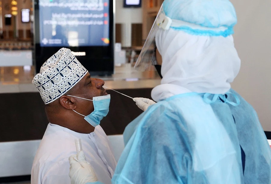 A medical worker collects a swab sample from a passenger for a RT-PCR Coronavirus test at the Muscat international airport in the Omani capital on October 1, 2020. (File/AFP)