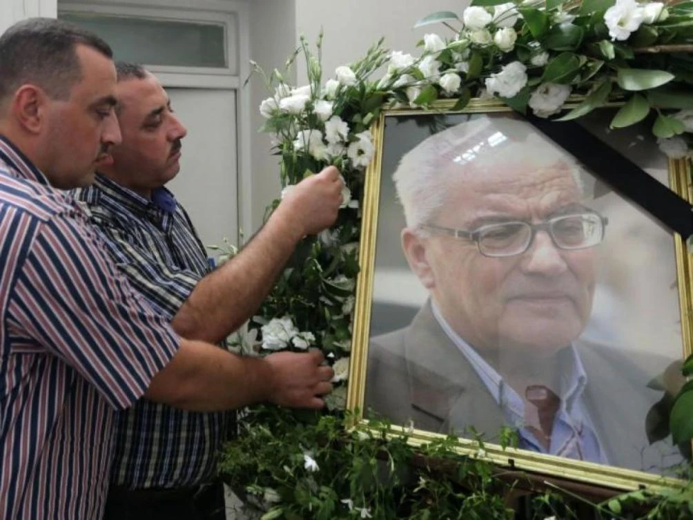 The sons of Khaled Al-Asaad, the late 83-year old retired chief archaeologist of Palmyra, Omar and Mohamad, display a portrait of their father during a ceremony at the National Museum in Damascus. (AFP)