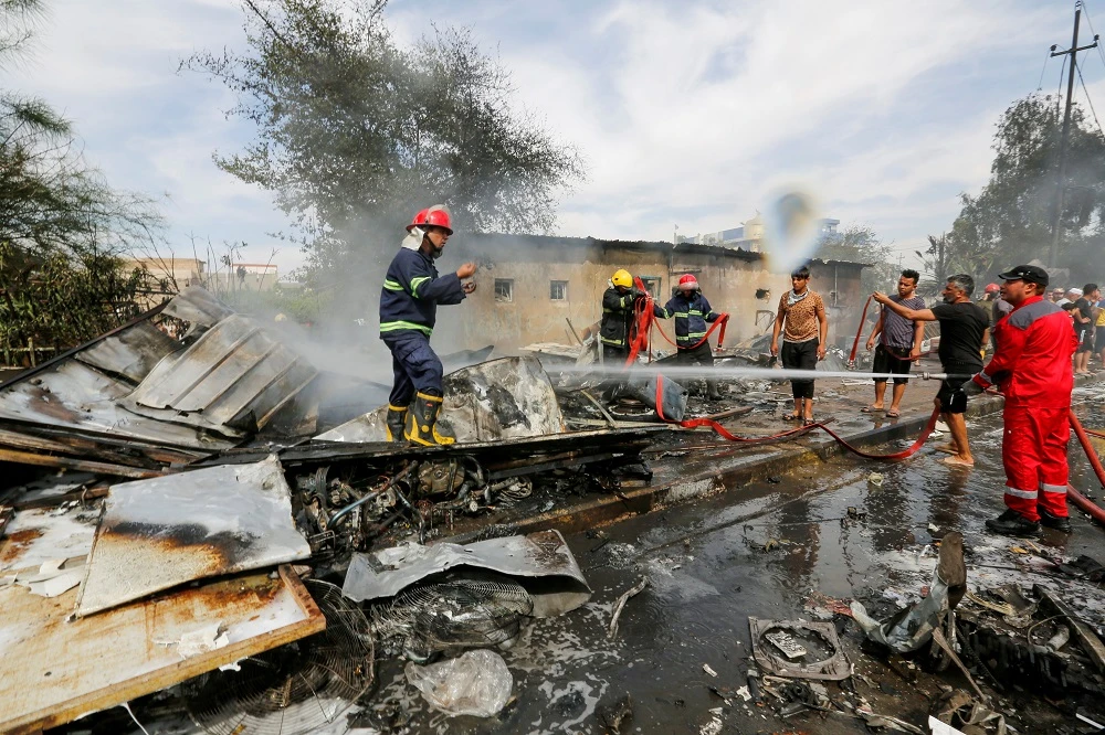 Firefighters inspect the site of a car bomb attack in Sadr City district of Baghdad. (Reuters)