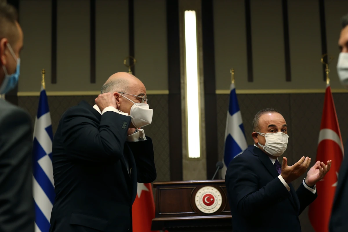 Turkish Foreign Minister Mevlut Cavusoglu, right, walks with Greek Foreign Minister Nikos Dendias, left following their joint media statement after their meeting in Ankara, Turkey, Thursday, April 15, 2021. (AP)