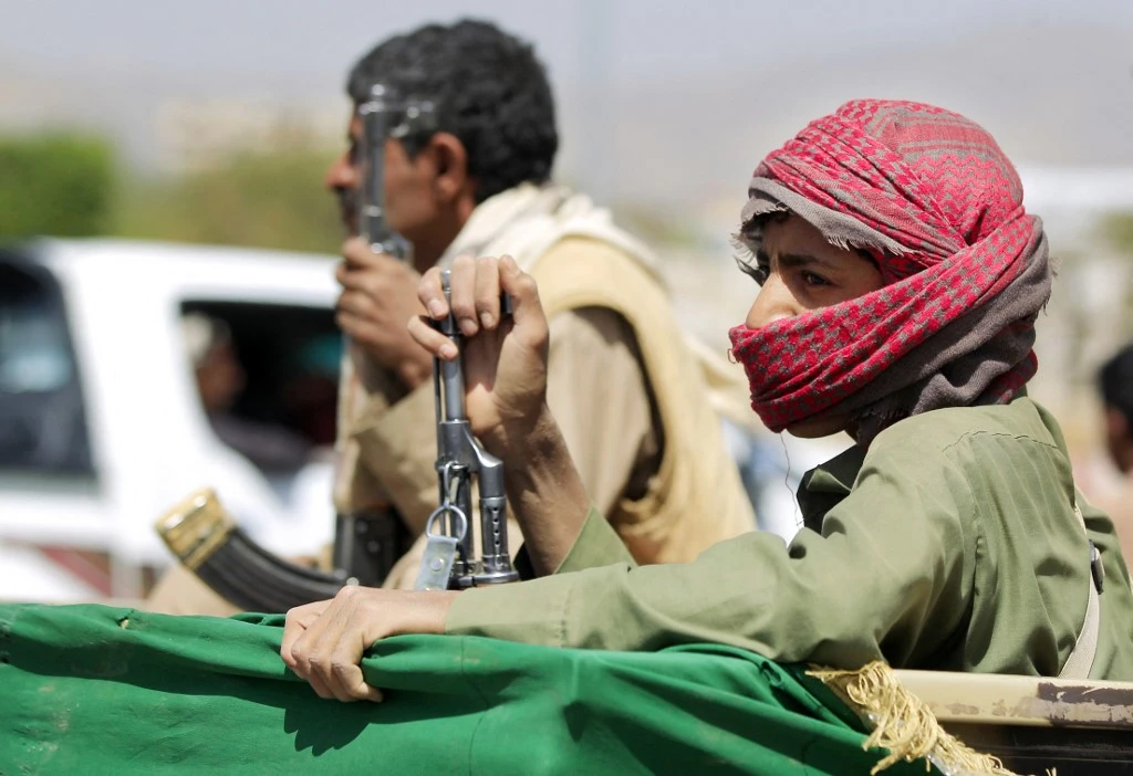 An armed supporter of Houthis sits in the back of a pick up. (File/AFP)