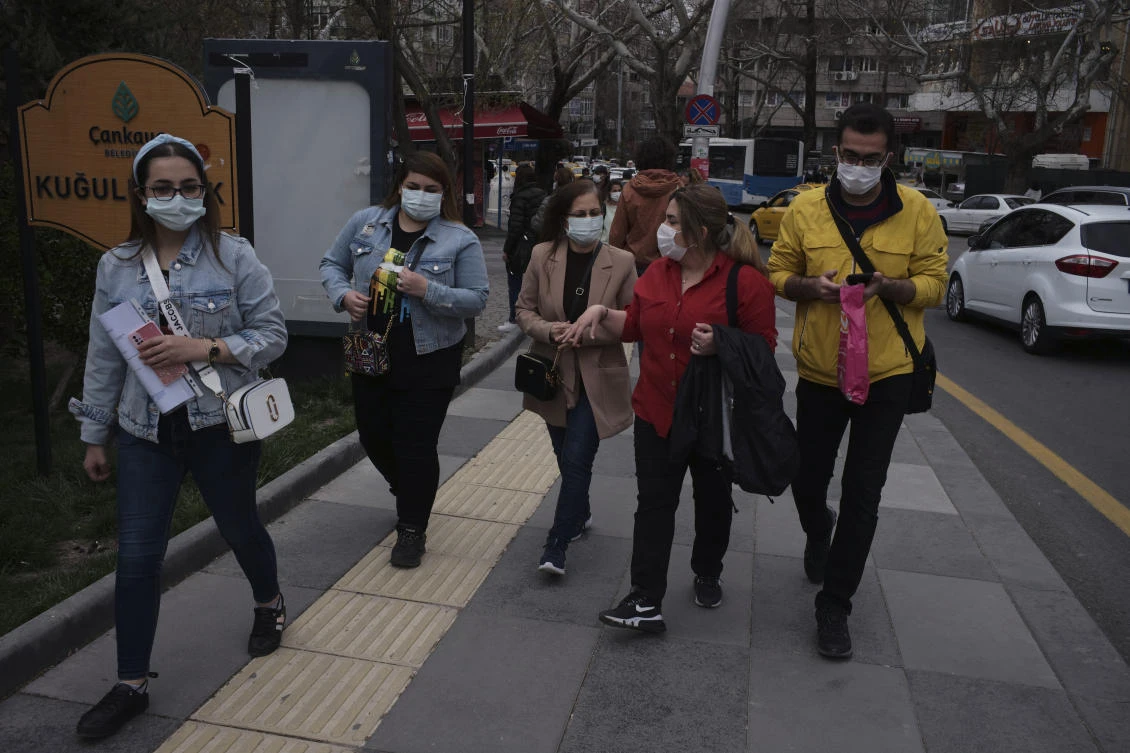 People wearing masks to help protect against the spread of coronavirus, walk along a street in Turkey that recorded 61,028 cases on Tuesday. (AP)