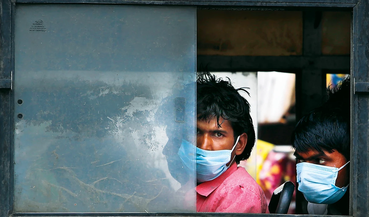 Migrant laborers sit in a bus to travel to their villages following a six-day lockdown put into place to control the rising cases of coronavirus infections, in New Delhi. (AP)