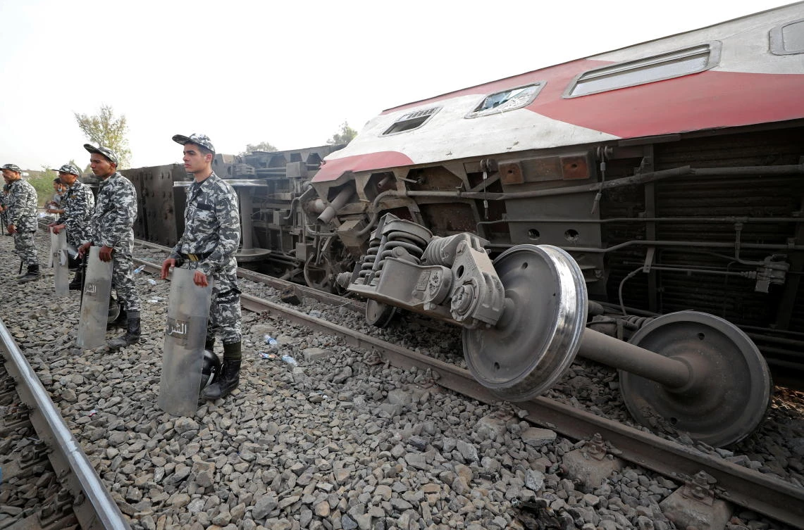 Egyptian police officers stand guard at the site where train carriages derailed in Qalioubia province, north of Cairo, Egypt April 18, 2021. (Reuters)