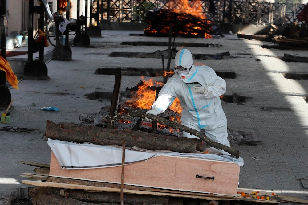 A man performs the final rites of a relative who died of COVID-19, at a crematorium in Jammu, India, Friday, April 23, 2021. (AP)