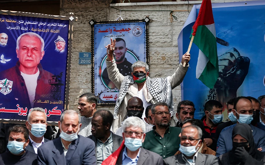 Palestinian demonstrators hold portraits as they gather during a rally in support of prisoners held in Israeli jails, in Gaza City, on April 18, 2021. (AFP/File)
