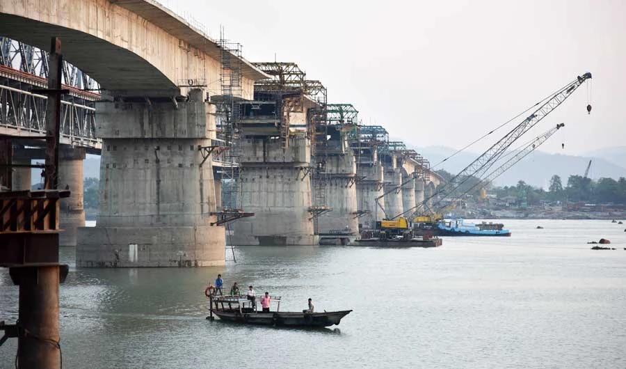 Indian labourers work on an under construction bridge across the River Brahmaputra in Guwahati in the north-eastern state of Assam. (AFP)