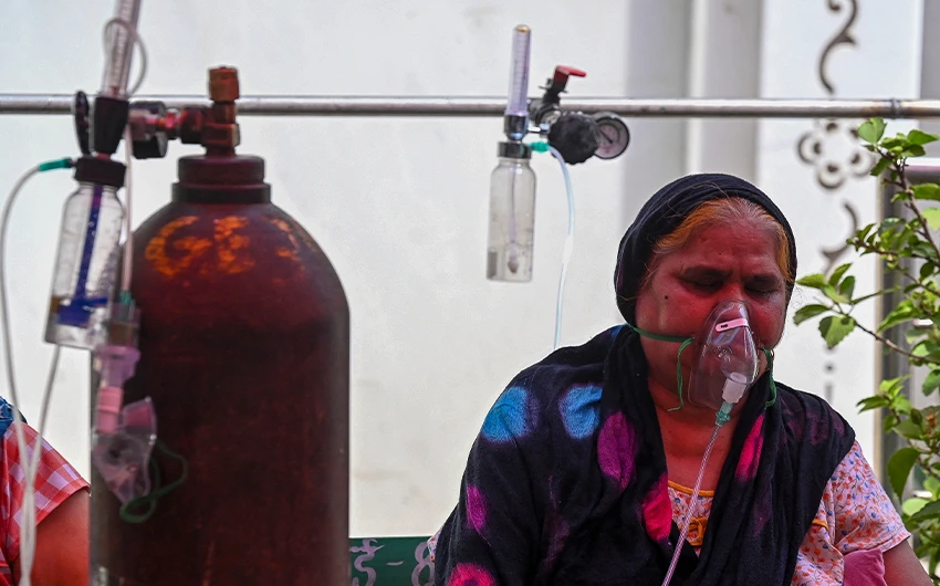 A Covid-19 coronavirus patient breathes with the help of oxygen provided by a Gurdwara, a place of worship for Sikhs, under a tent installed along a roadside in Ghaziabad on April 28, 2021. (AFP/File)