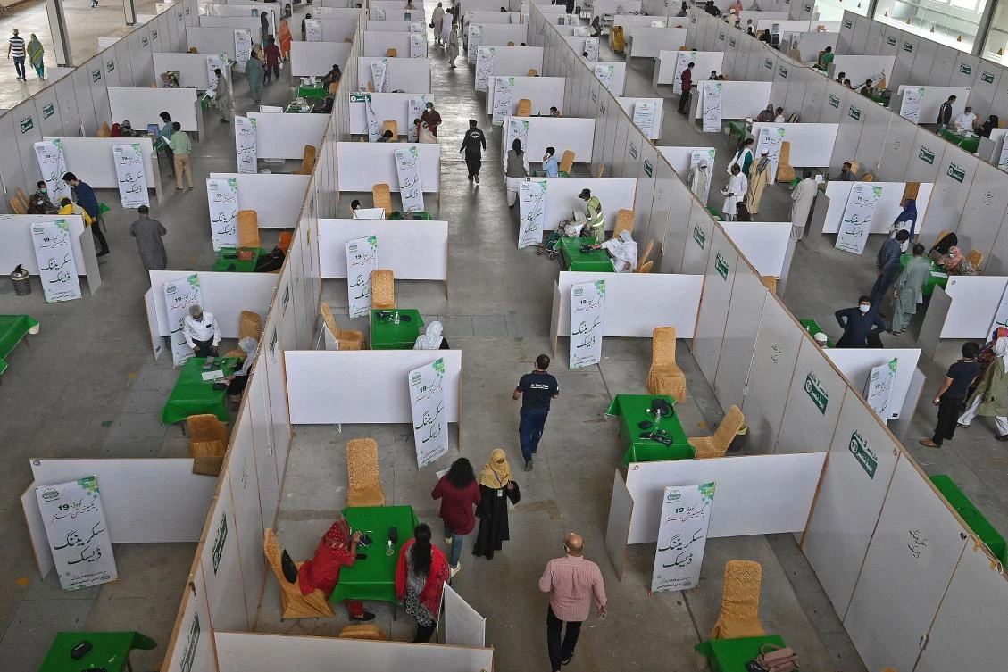 People gather to get themselves inoculated with the Chinese-made Sinopharm Covid-19 coronavirus vaccine at a vaccination camp organised at the Expo center in Lahore on April 28, 2021. (AFP)