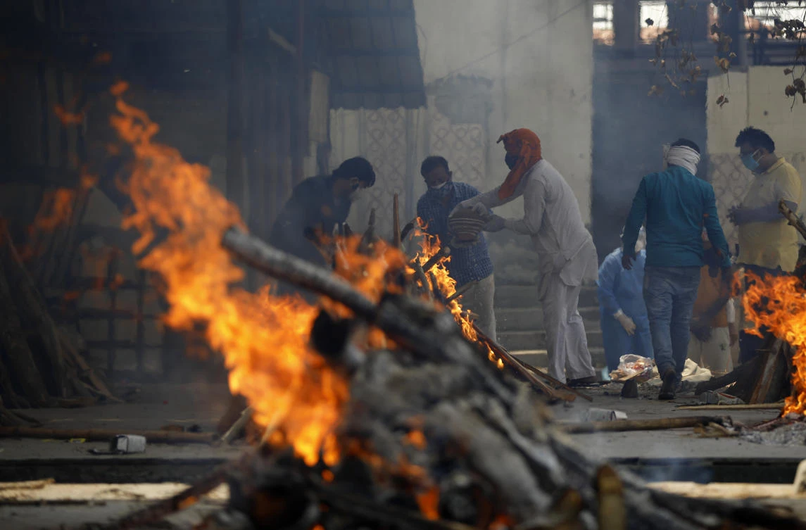 Multiple funeral pyres of COVID-19 victims burn as relatives perform last rites at a crematorium in New Delhi, India, April 30, 2021. (AP Photo)