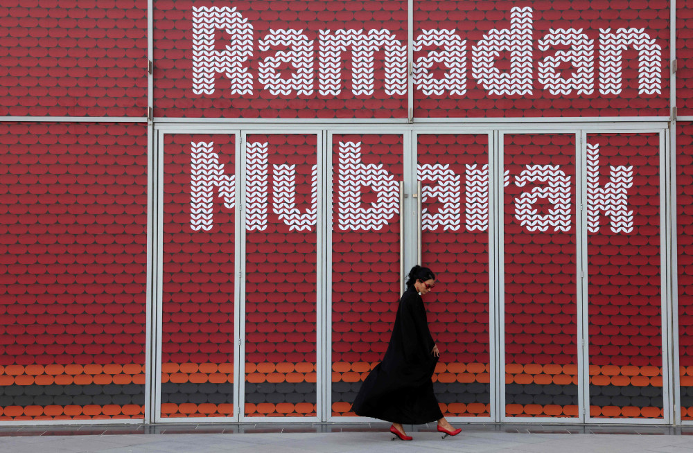 A woman walks past an installation with the message Ramadan Mubarak (blessed), on May 3, 2021 in Dubai's Design District, during the Muslim holy fasting month of Ramadan. (AFP)