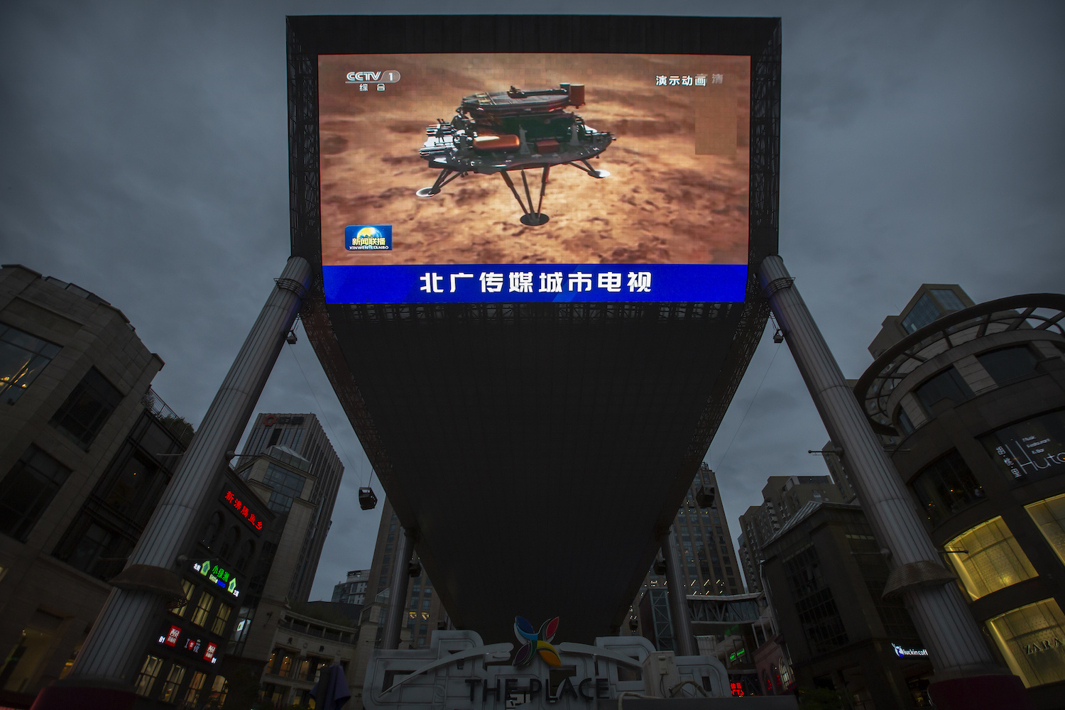 A news report about China’s successful landing of a probe on Mars is shown on a large video screen in a Beijing shopping mall-AP