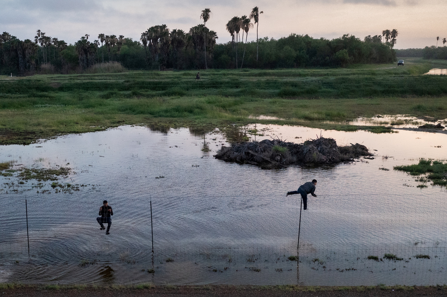Migrants jump a fence as they run towards Mexico while being chased by US border patrol after crossing the Rio Grande river into the US from Mexico. (Reuters)