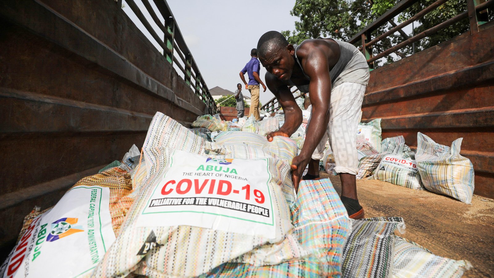 Men load sacks of rice along with other food aid onto a truck, amid an outbreak of COVID-19, Abuja, Nigeria, April 17, 2020. (Reuters)