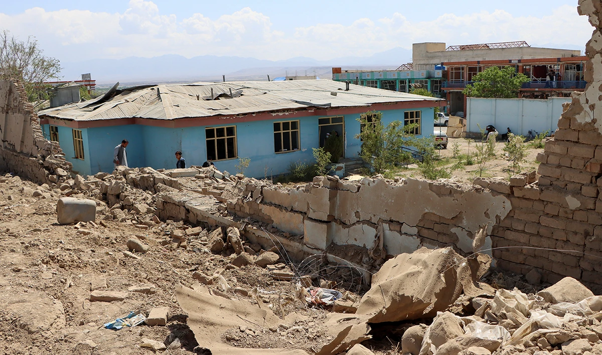 Afghan men inspect the area near a building at the site of last night's car bomb blast, in Logar province, Afghanistan May 1, 2021. (Reuters)