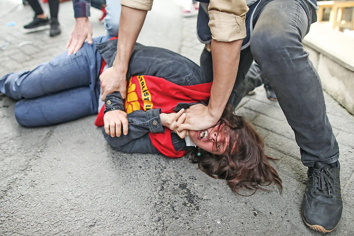 A policeman detains a protester after she and others tried to push through a police barricade toward Taksim Square in Istanbul during Saturday’s May Day protests. (AP)