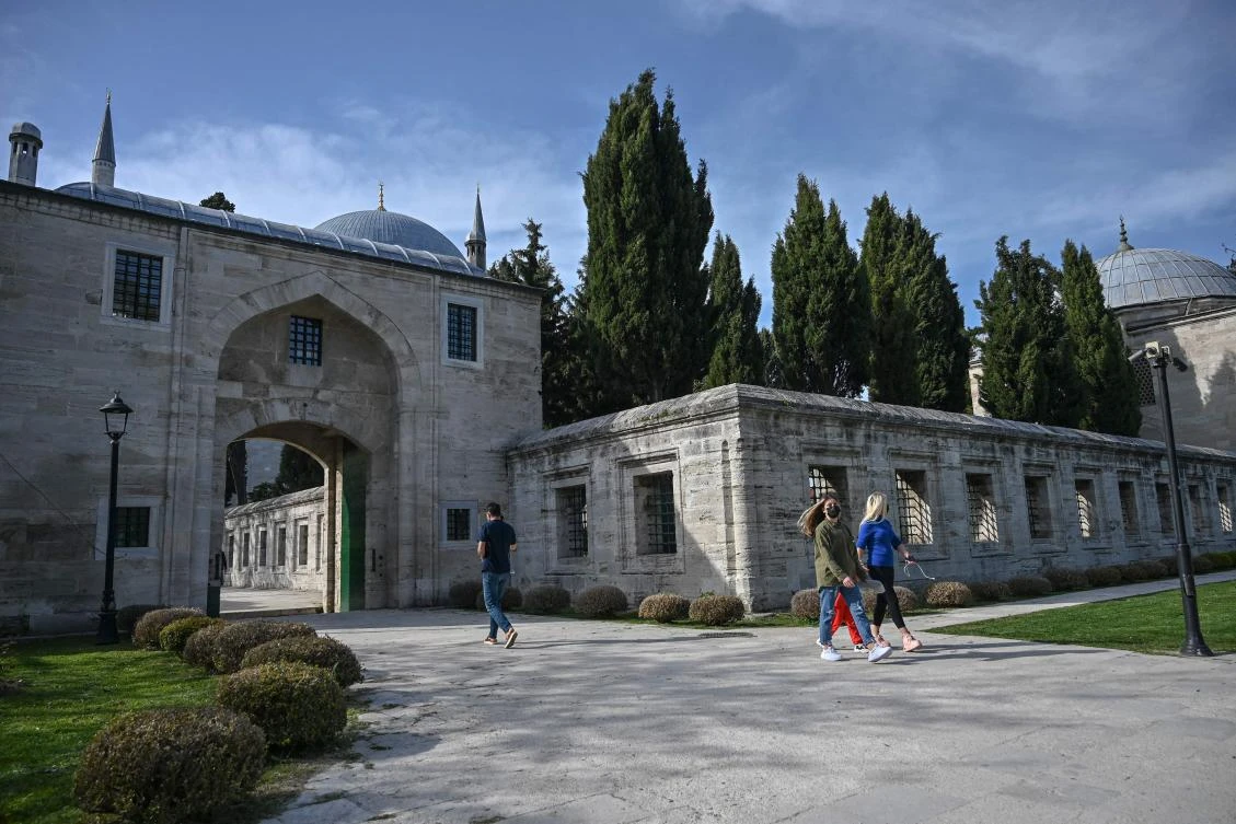 Tourists walk on the site of the Suleymaniye mosque in Istanbul, during a new lockdown aimed at fighting a surging third wave of COVID-19 infections. (AFP)