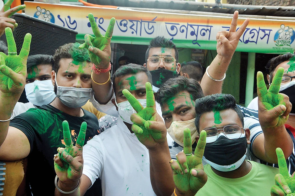 Supporters of the All India Trinamool Congress (AITC) celebrate the party’s lead during the counting process of the West Bengal legislative assembly election. (AFP)