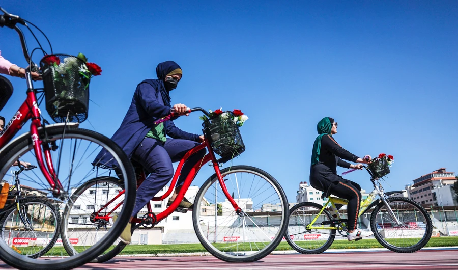 Palestinian women ride bicycles at the Yarmouk Stadium in Gaza city on April 28, 2021. (AFP)