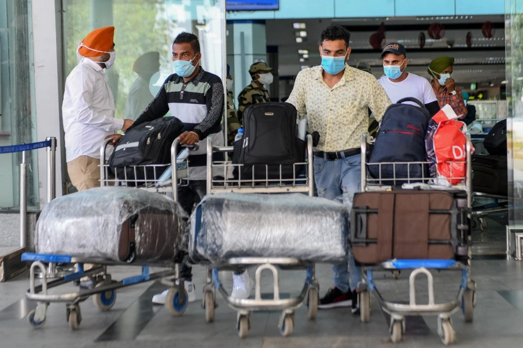 Indian nationals after returning from Sharjah in the UAE with a special flight arrive before boarding a bus taking them to a quarantine facility at Sri Guru Ram Dass Jee International Airport on the outskirts of Amritsar on July 15, 2020. (File/AFP)