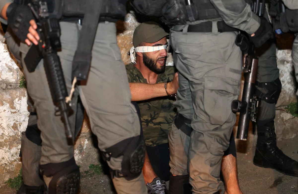 A Palestinian demonstrator is blindfolded and surrounded by Israeli security forces during protests against the forced evictions of Palestinian families in East Jerusalem. (AFP)