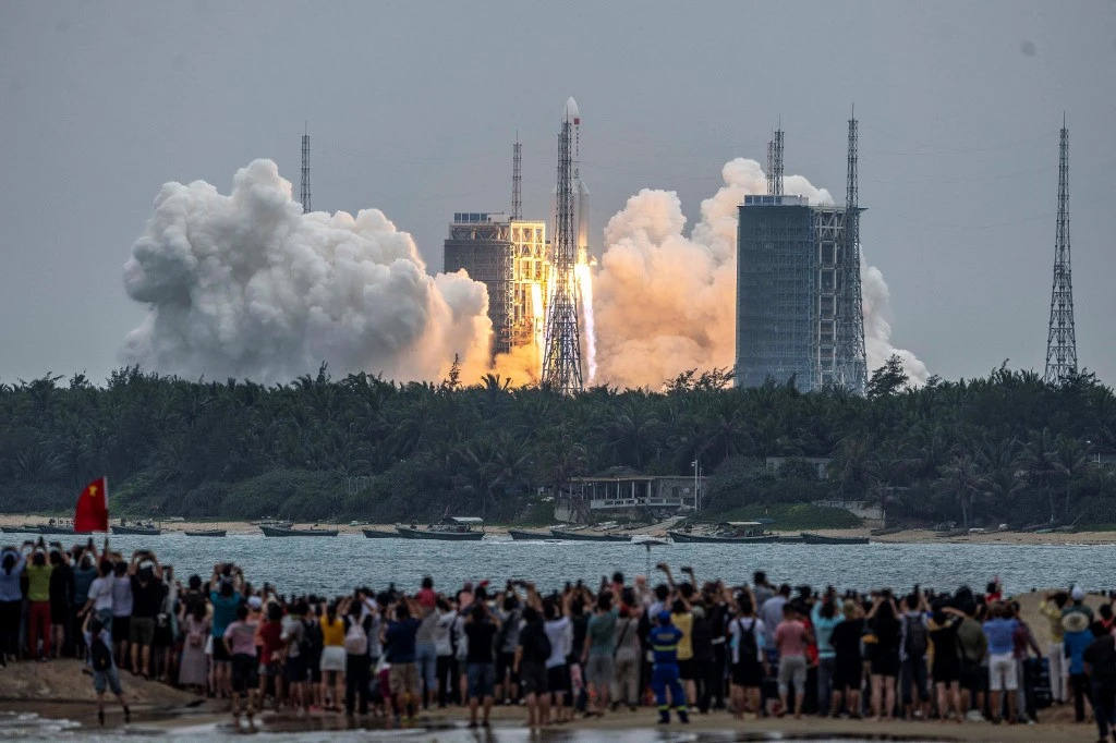 In this file photo taken on April 29, 2021, people watch a Long March 5B rocket, carrying China's Tianhe space station core module, as it lifts off from the Wenchang Space Launch Center in southern China's Hainan province. (File/AFP)