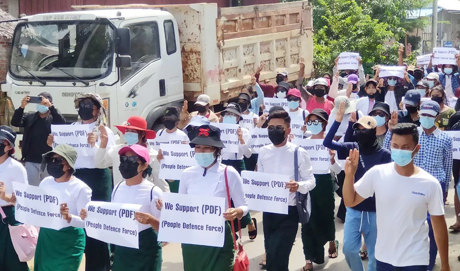 This handout photo taken on May 7, 2021 shows protesters holding up signs supporting the "People's Defence Force" during a demonstration against the military coup in Dawei. (AFP)