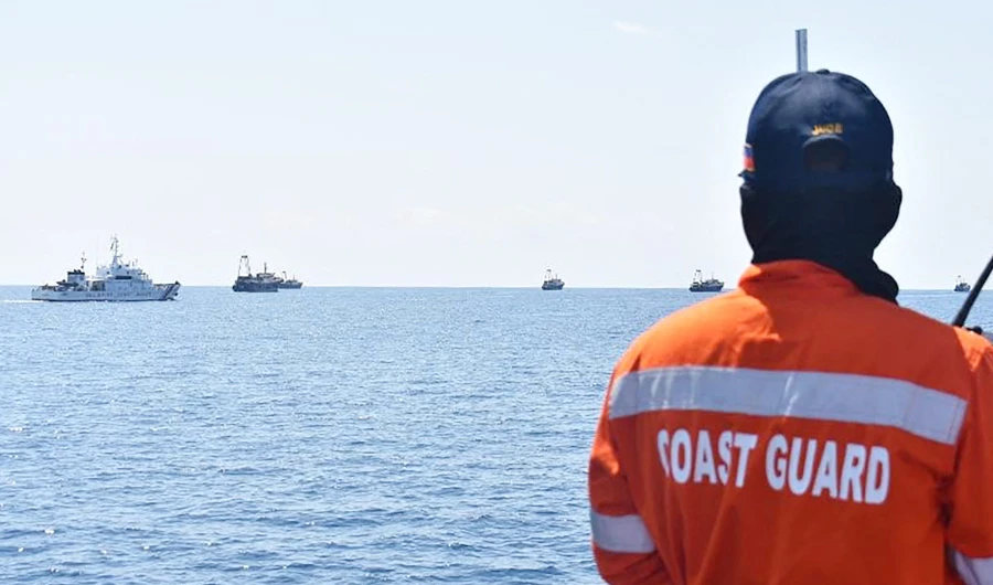 This file photo taken on April 27, 2021 shows Philippine coastguard personnel aboard their ship BRP Cabra monitoring Chinese vessels (R) at Sabina Shoal west of the Philippine island of Palawan. (AFP)