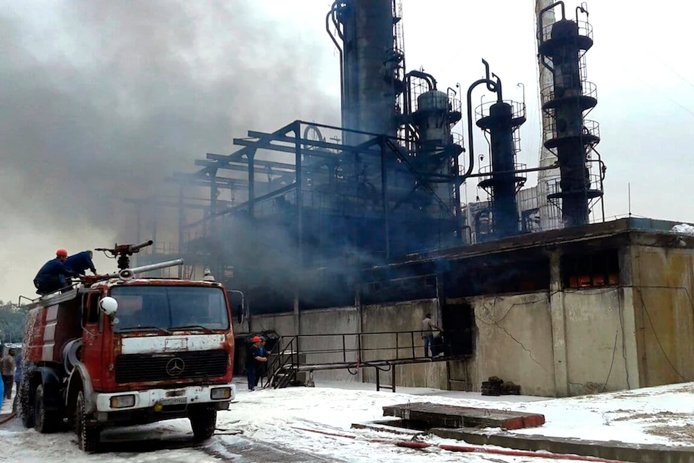Firefighters put out a fire at the Homs Oil Refinery in the central province of Homs. (AP)