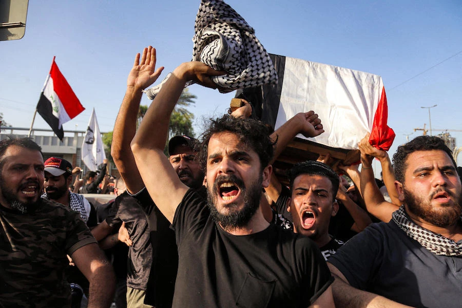 People chant slogans as they march with the body of renowned Iraqi anti-government activist Ihab al-Wazni (Ehab al-Ouazni) during a funerary procession in the central holy shrine city of Karbala on May 9, 2021 following his assassination. (AFP)