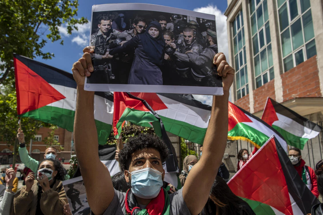 Protesters shout slogans and wave Palestinian flags in support of Palestinians during the latest round of violence, outside the Israeli embassy in Madrid. (AP)